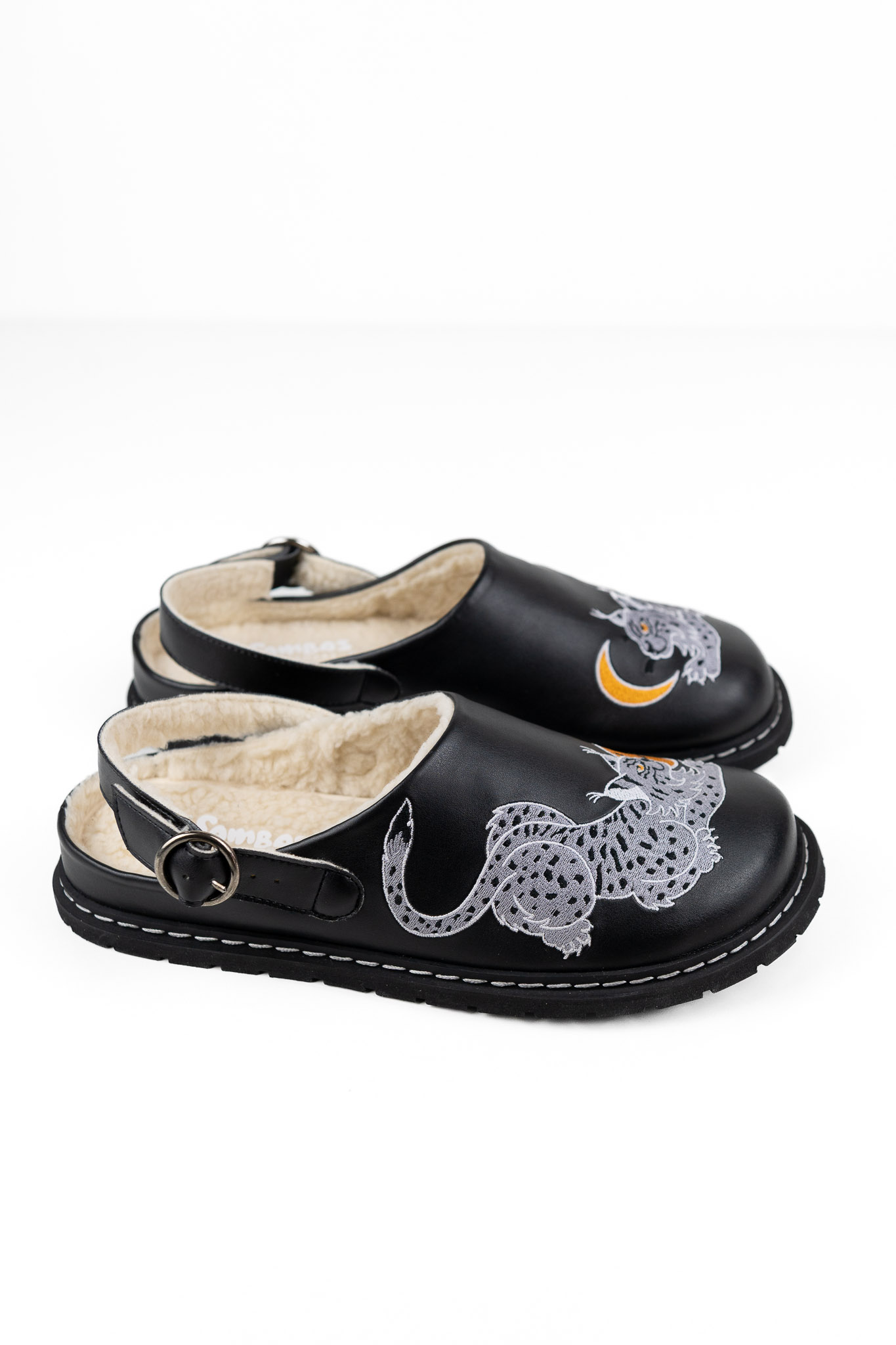 LUNX barefoot clog in black from the side, with the embroidered lynx and shearling lining